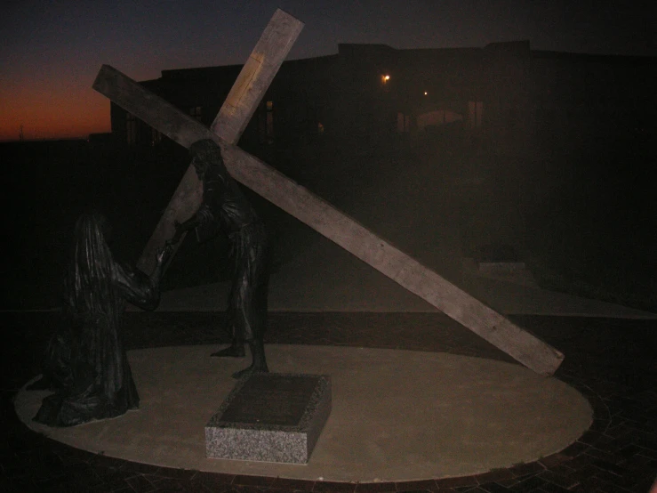 there is a large cross next to the statue
