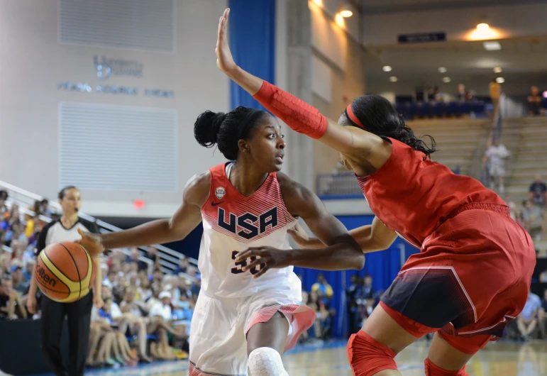 two girls basketball players chasing after the ball