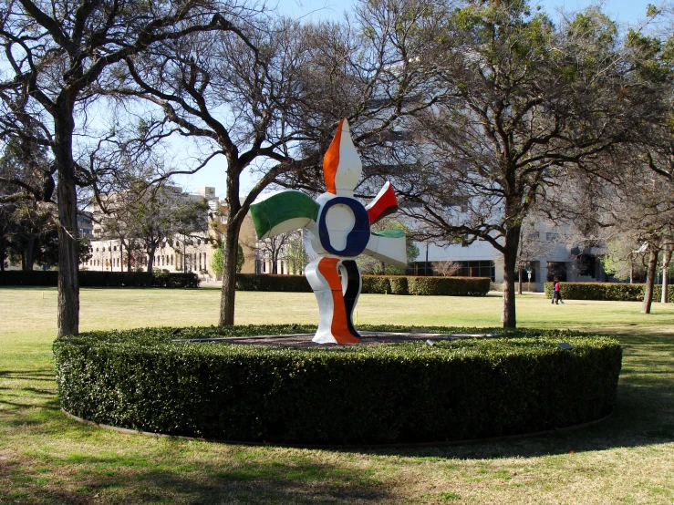 a sculpture of a flower is in a round grass area