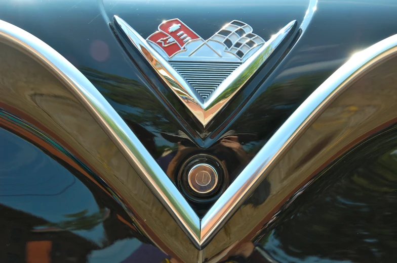 a shiny gold emblem on the front of an antique car