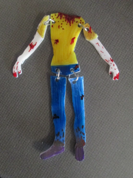 a toy of a man in a yellow shirt and jeans with chains is on the floor