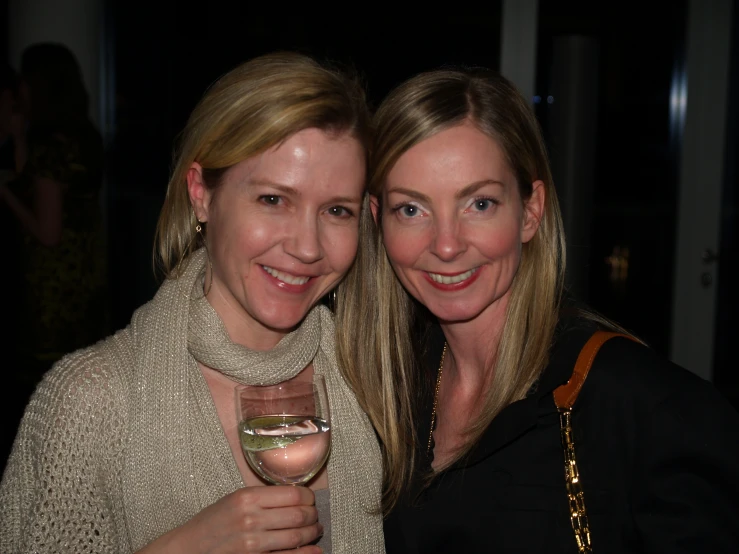 two women holding wine glasses in their hands