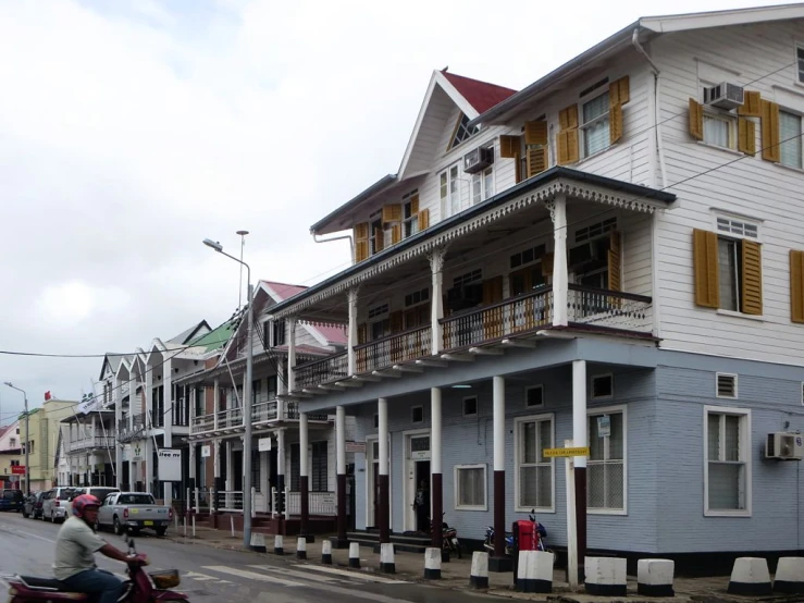 a man is on a motorbike passing a building