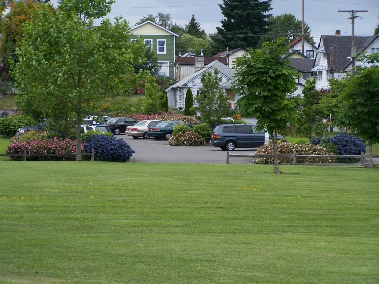 an apartment complex is seen in the background as cars drive past