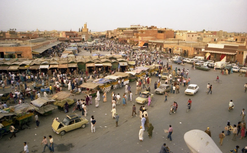 a crowd of people walking through an open street