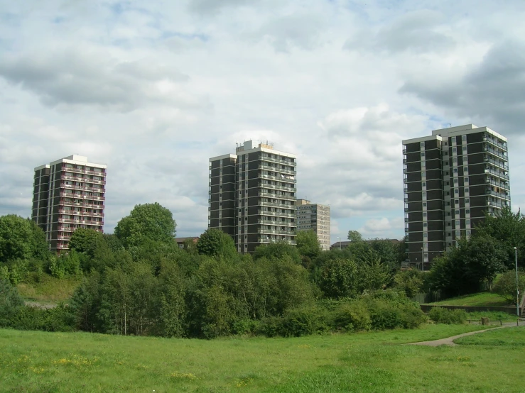 a group of three apartment buildings in a field