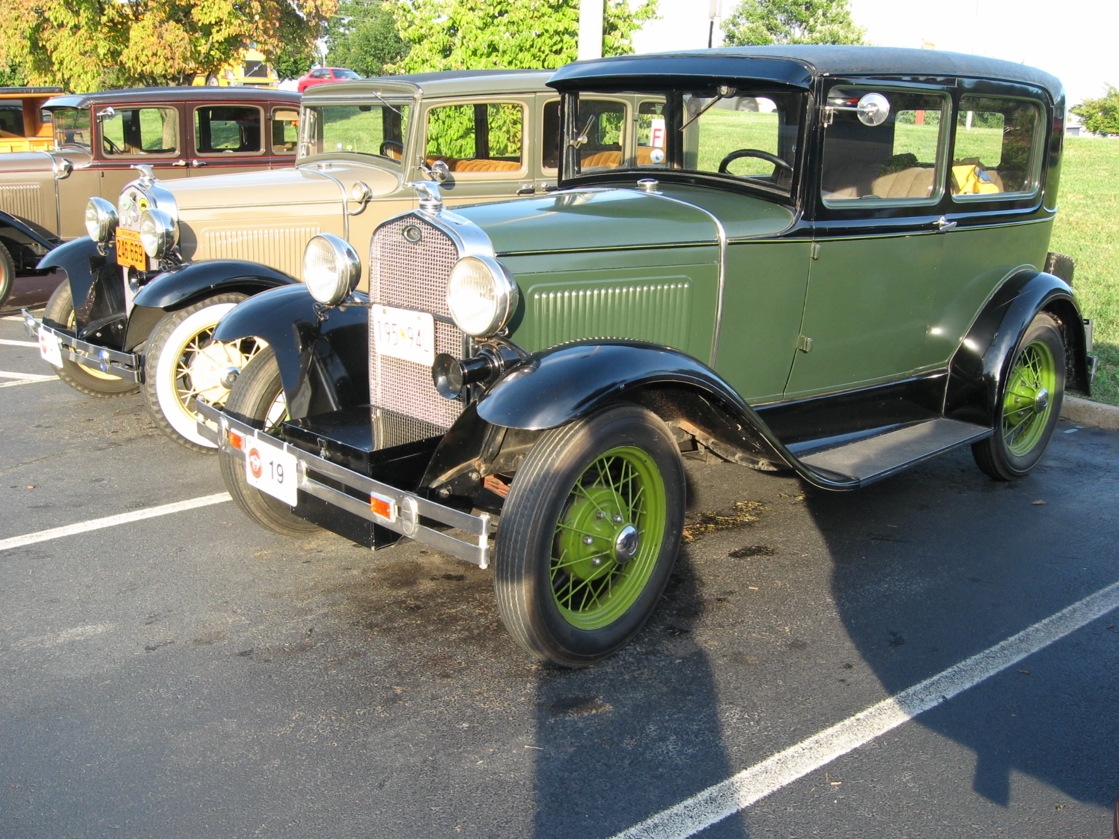 two old time cars sitting in a parking lot
