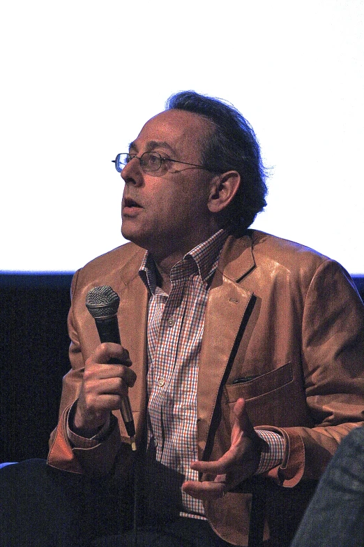 a man in a suit speaking at an event