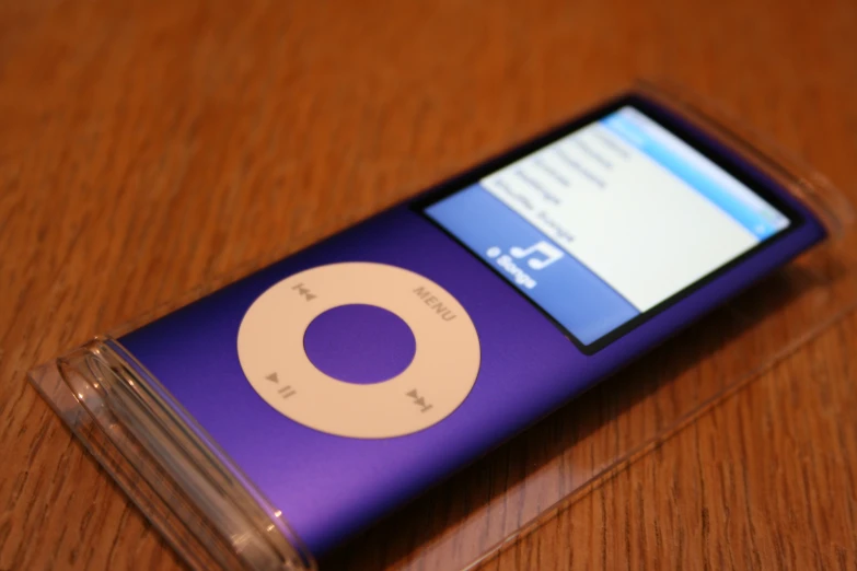 a cell phone has a purple case and is resting on the wooden table