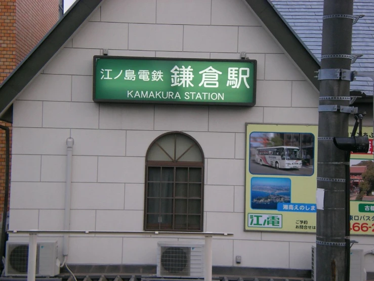 a large white building with green signage in english and chinese