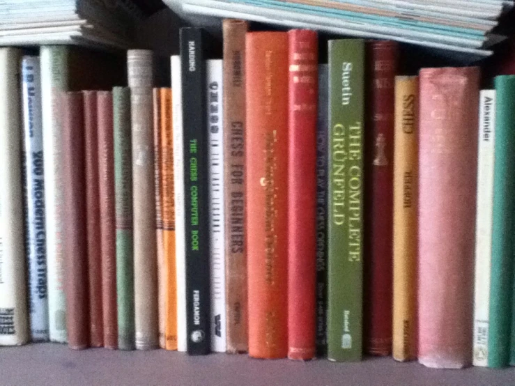 a book case filled with books on top of a white shelf