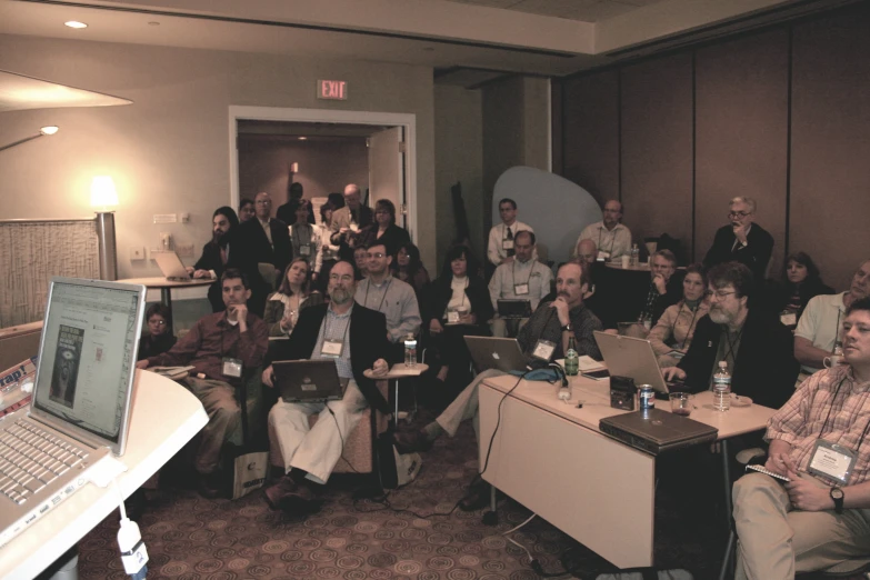 a group of people with laptops in a room