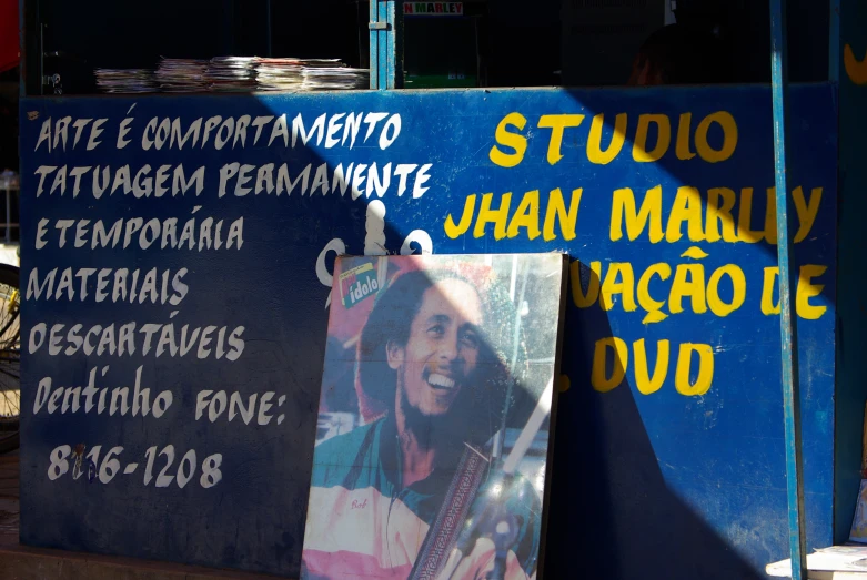 a pograph of a man standing next to an advertising sign