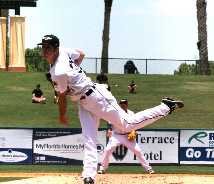 the baseball player is sliding into his leg after a pitch