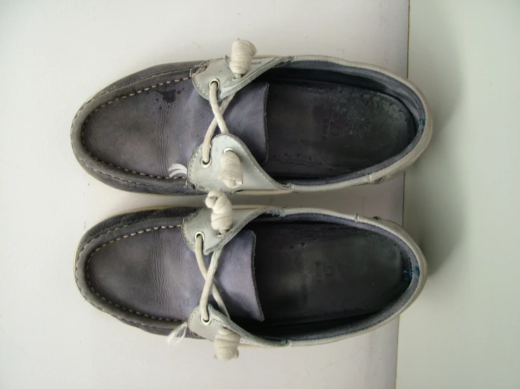 a pair of gray shoes with white laces hanging on the shoe