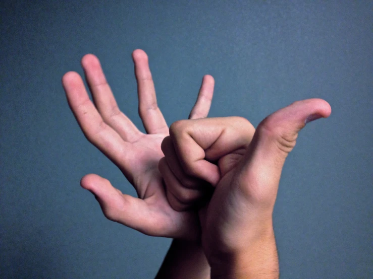 a man is doing a hand gesture against a blue background