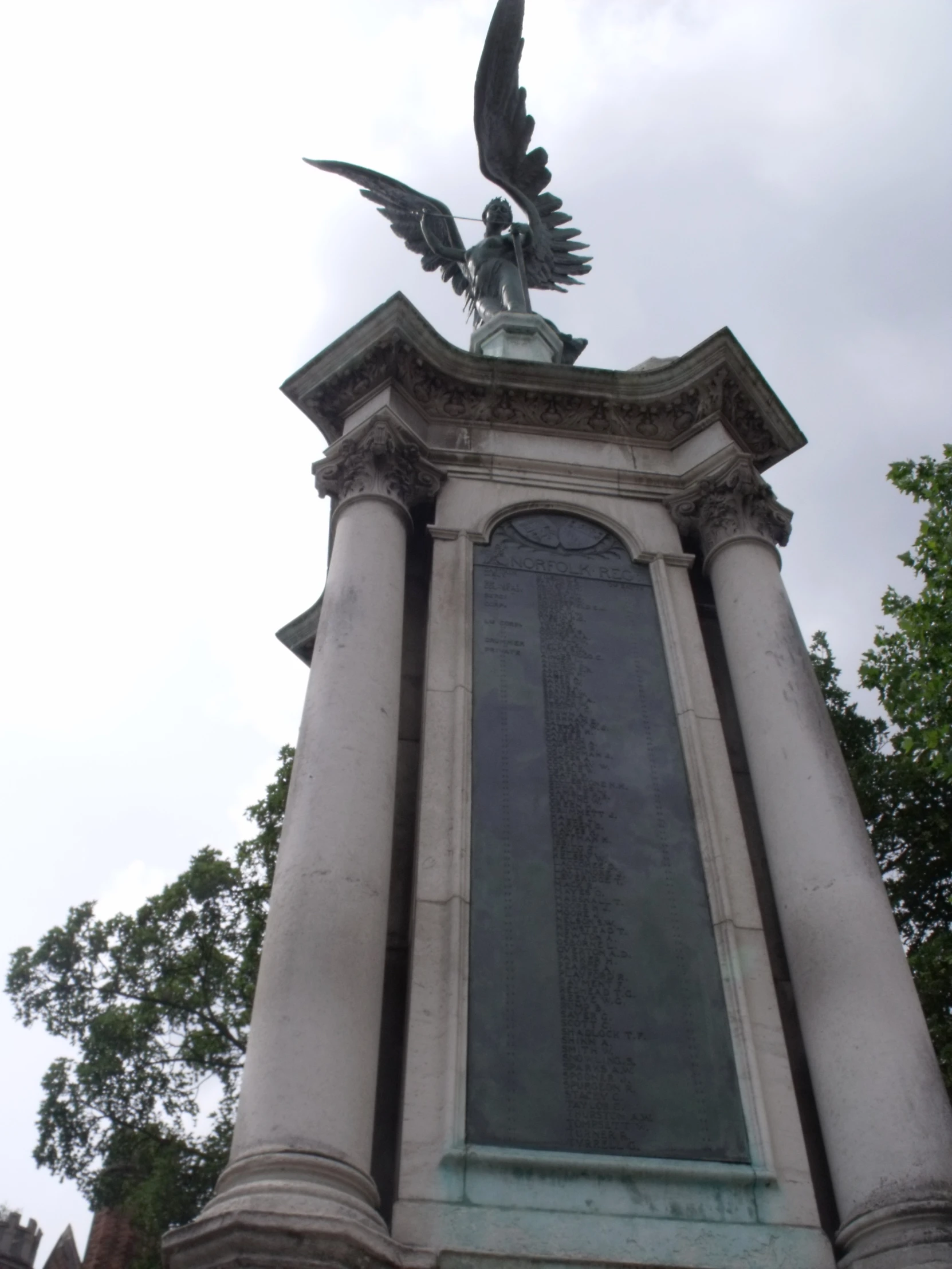 the statue has a bird on it's head and wings