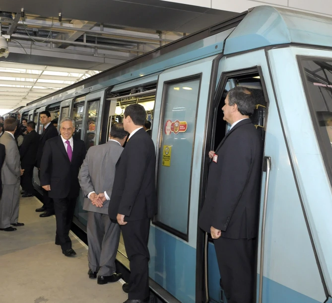 a group of men in business suits getting off of a train