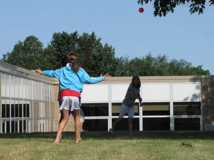 two people standing on a field near a fence