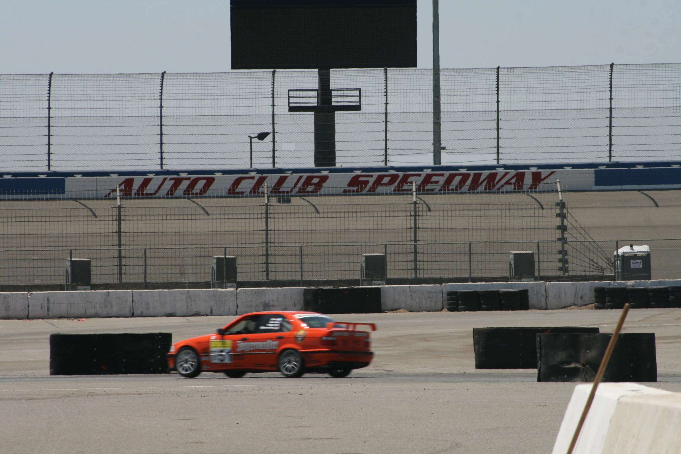 an orange mini car driving on a race track