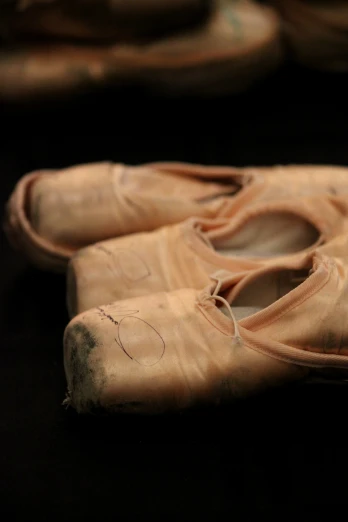 three old dirty ballet shoes that are laying on the floor