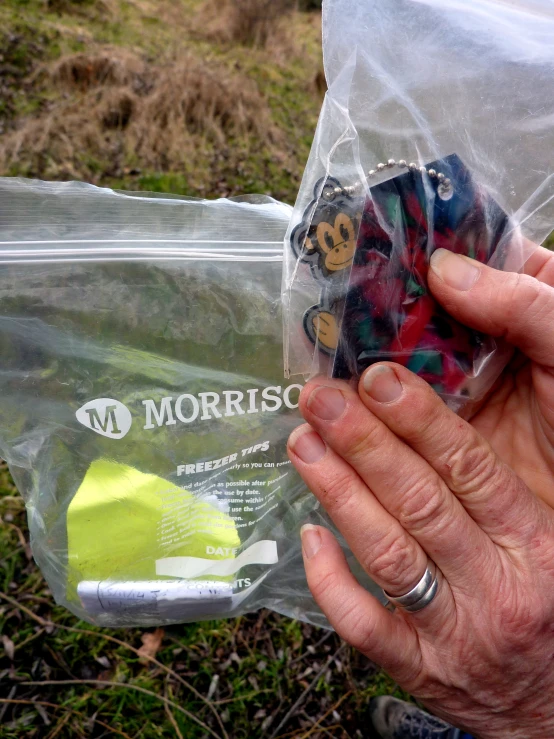 a person is holding two plastic objects wrapped in plastic