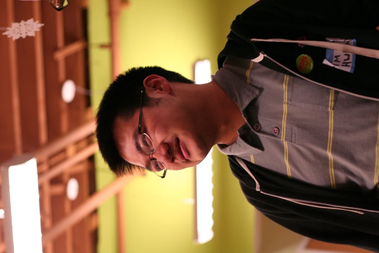 an asian male in a black and yellow shirt is posing for a picture