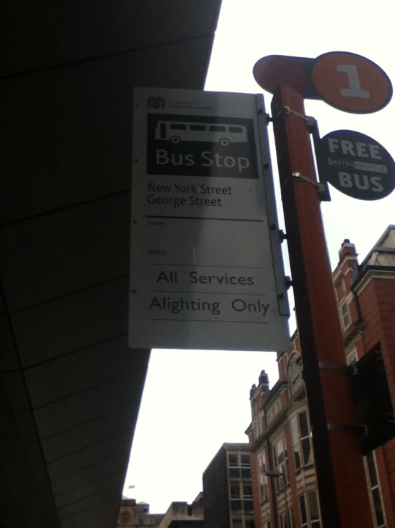 a street sign with bus stop, no stopping signs and a free bus sign