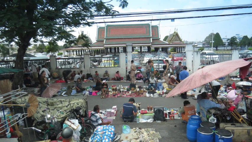 people at an open air flea market by a temple