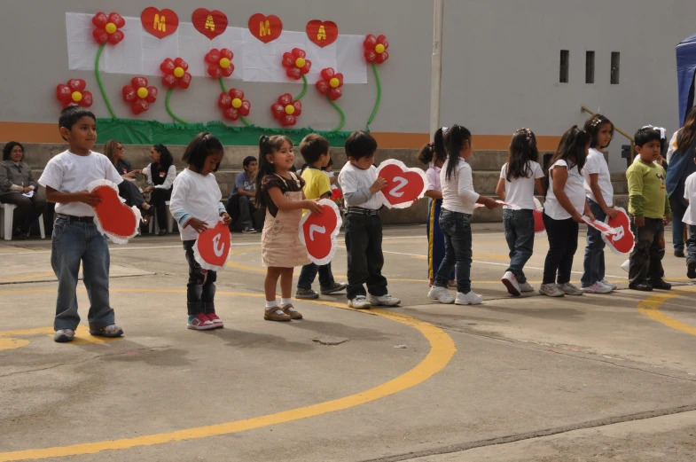 a group of children holding up signs in front of a crowd