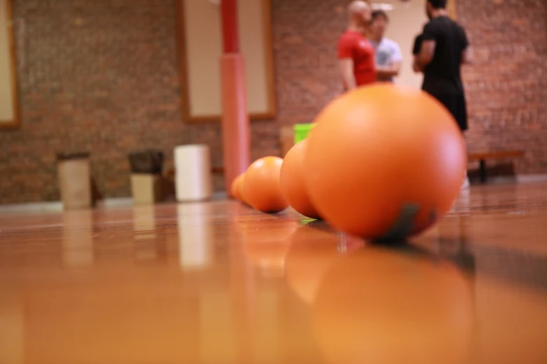 three oranges and two men in a building