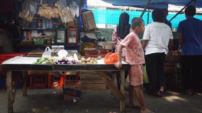 a group of people gathered around a table filled with items