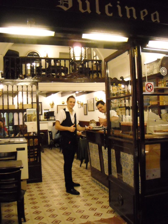two men working in the kitchen inside of a restaurant