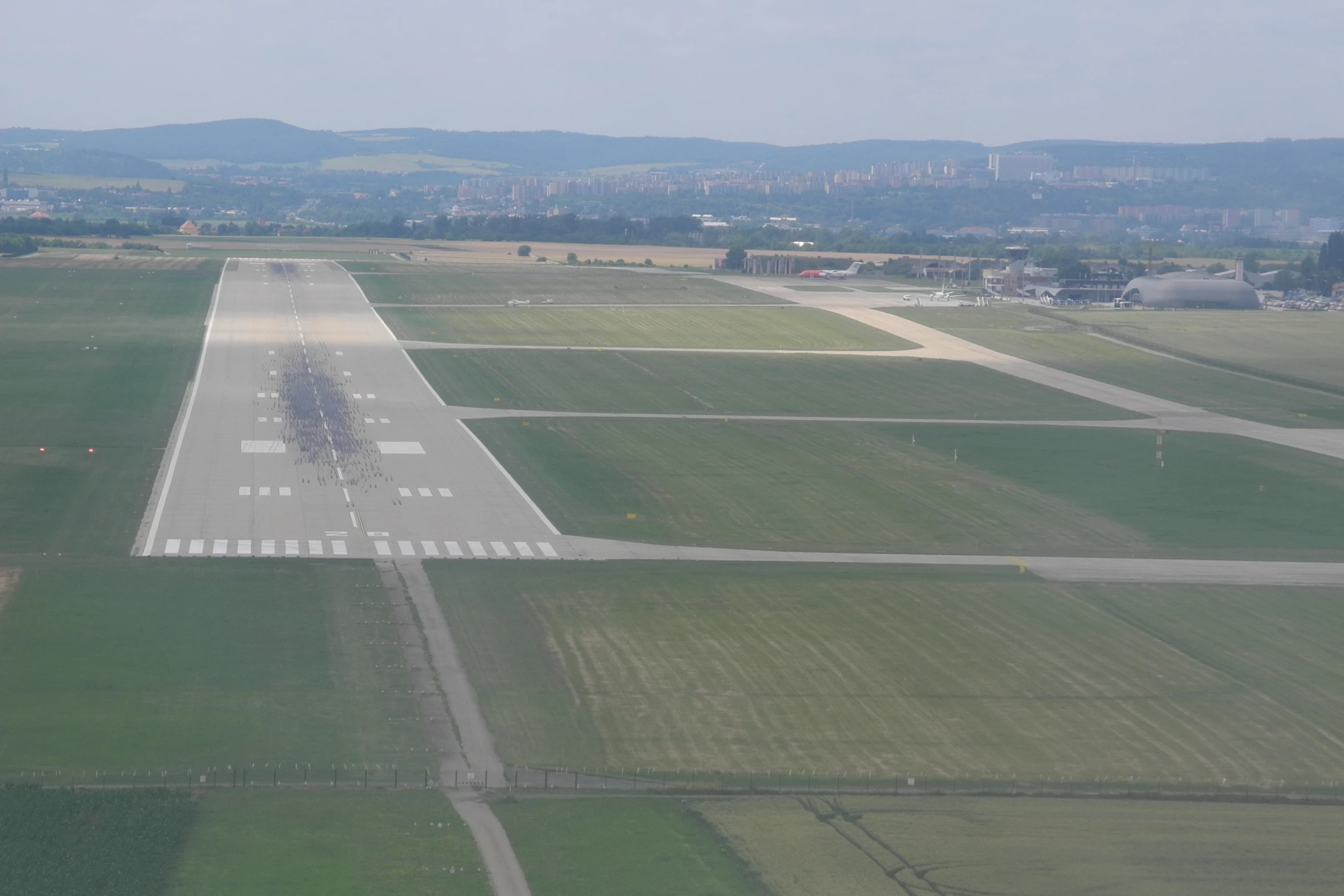 a landing strip with a plane taking off in the distance