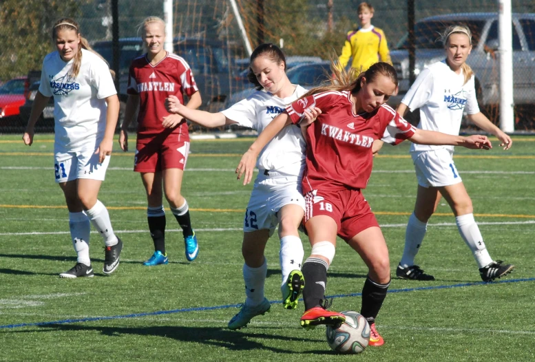 two girls on opposing teams play a soccer game