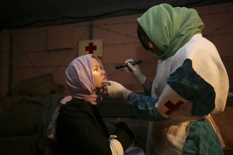 a doctor checking on a woman's face while wearing costume