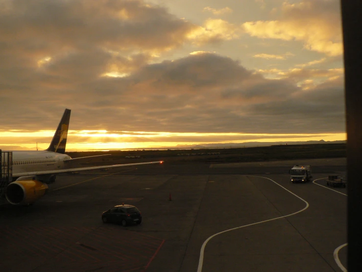 the airplane is being prepared for take off and some cars on the runway