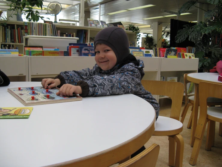 a  is sitting at the table playing with toy blocks