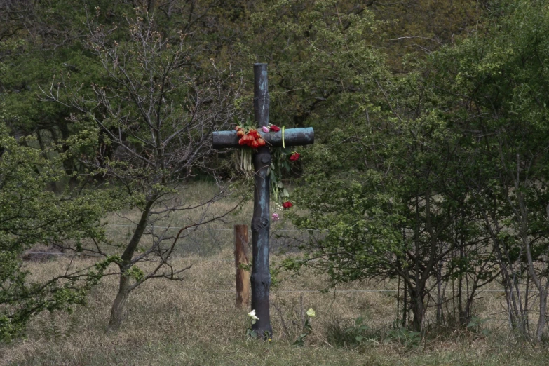 a pole decorated with flowers and candles sitting in the grass