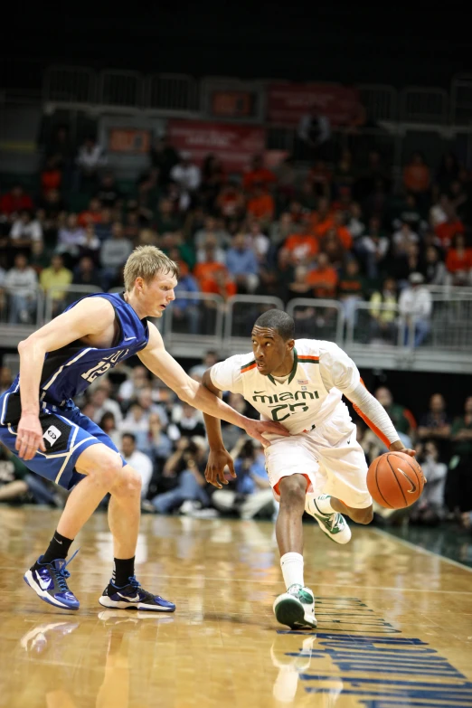 a man going after a basketball on a court while another player grabs the ball