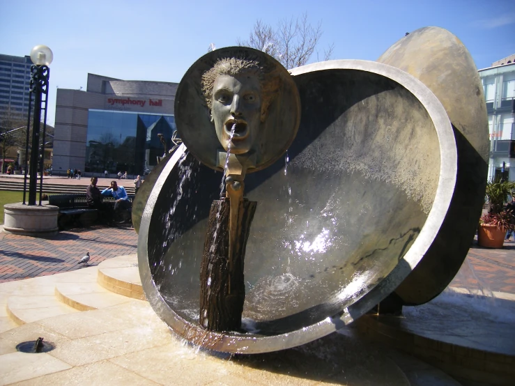 a fountain with a sculpture and a water feature behind it