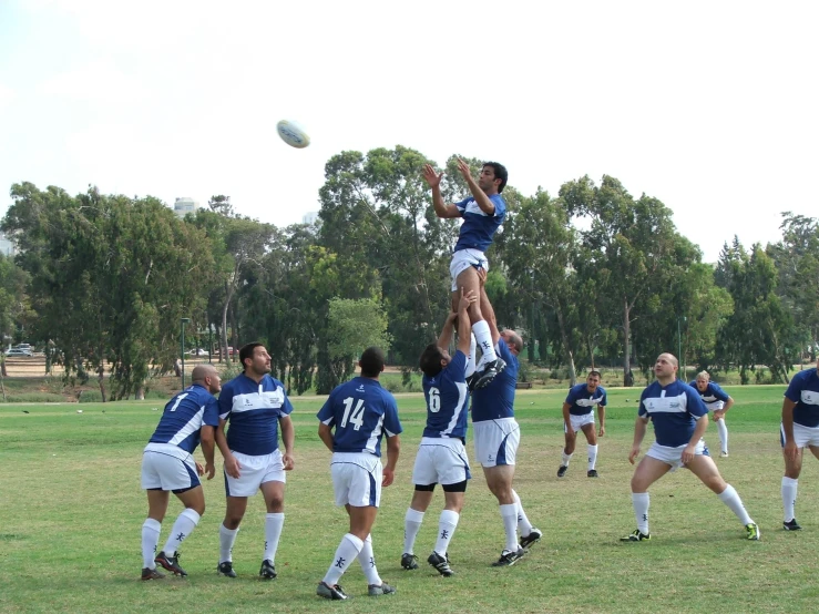 several people in uniforms playing soccer on the field