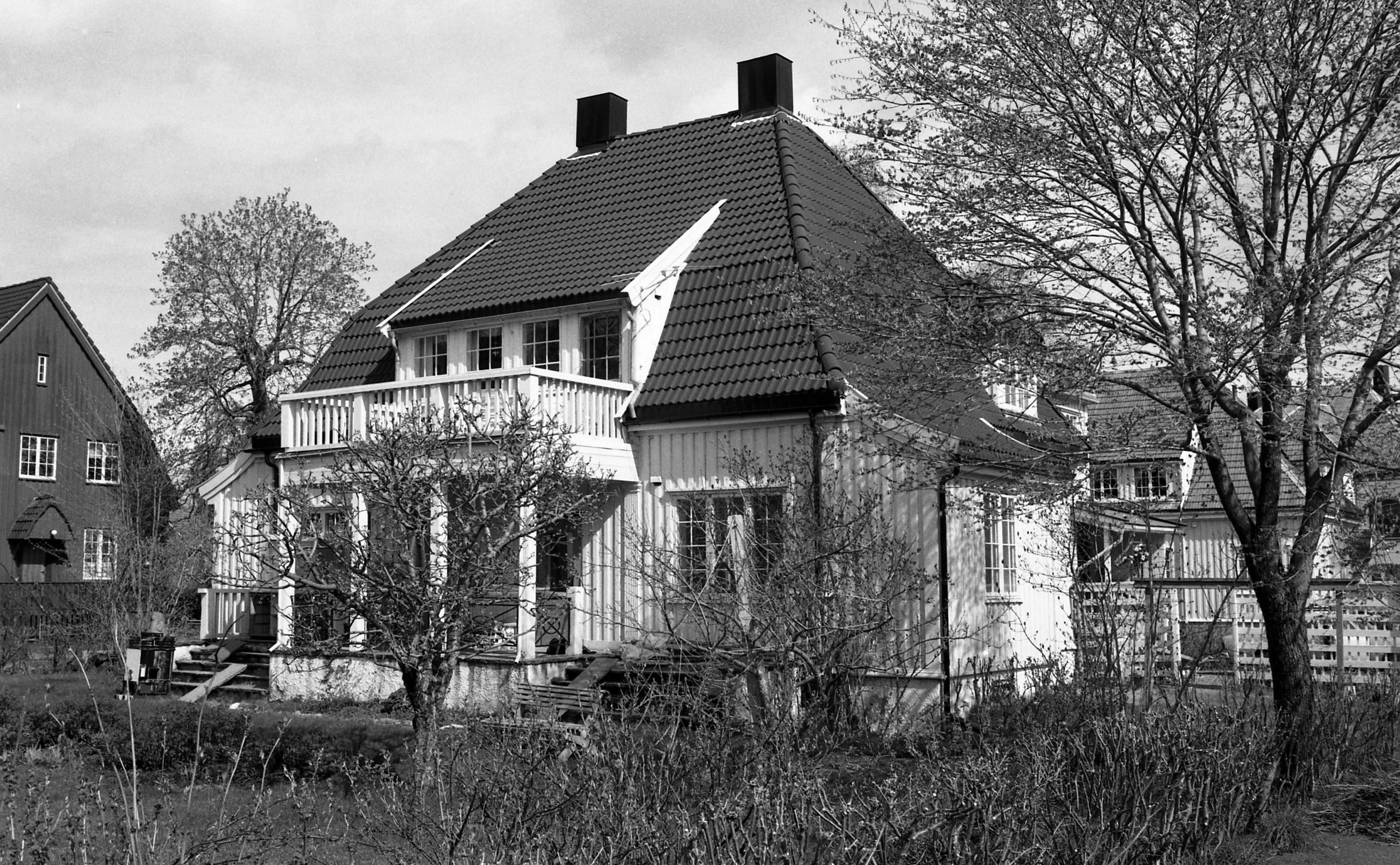 a few houses, one with a fence and the other in front of it