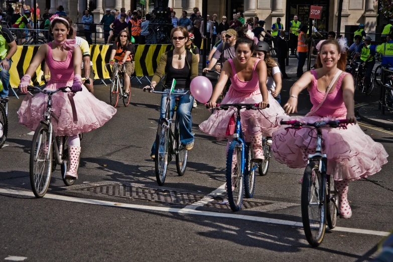 a group of girls riding bikes down the street