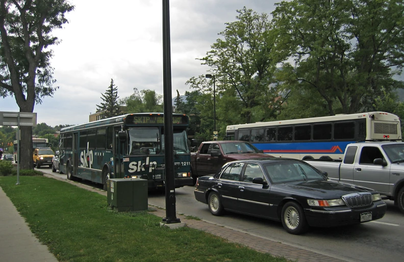 a black car is stopped on a street near traffic