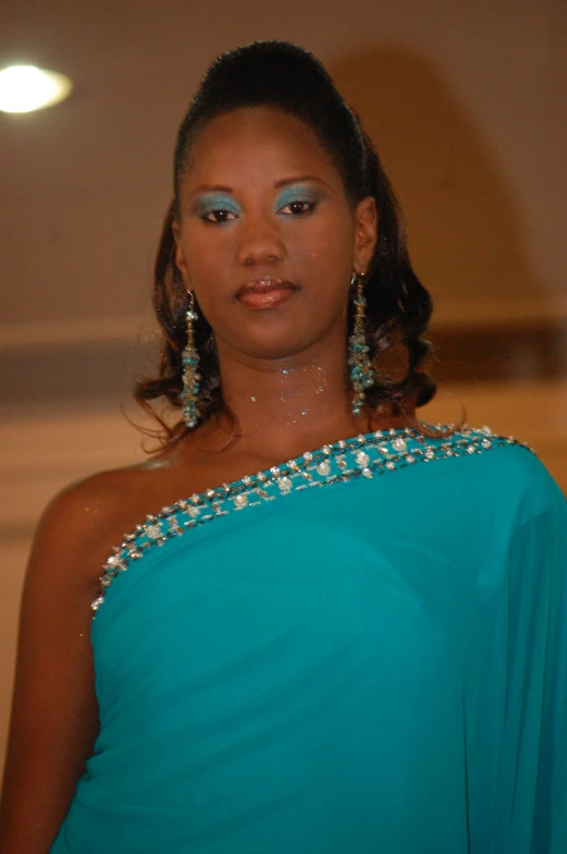 a woman in an aqua blue dress with jewelry