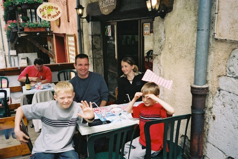 people sitting around a table and making stop gesture