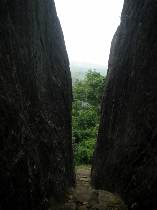 a narrow dirt path between two very large rocks