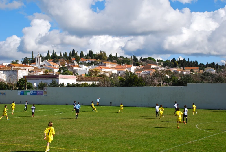 several young men in yellow soccer uniforms standing on the field