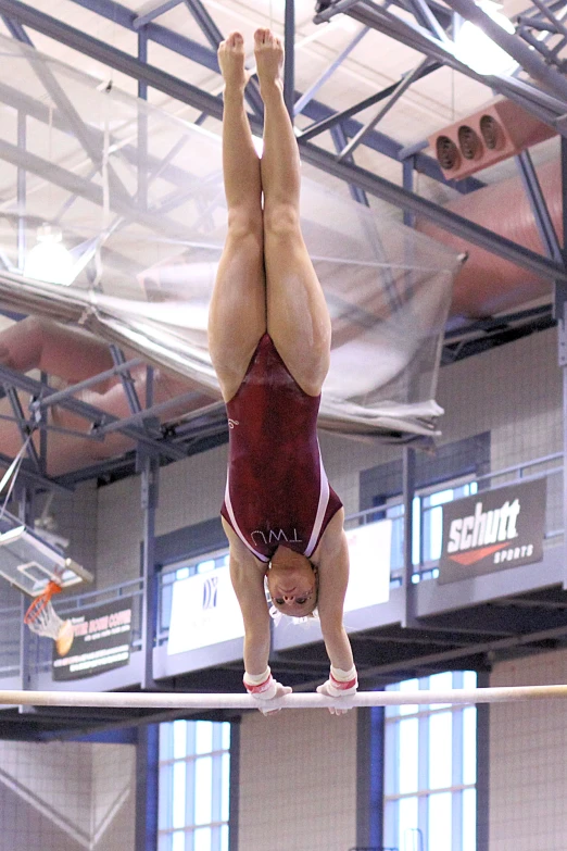 a woman is doing some gymnastics stunts on the horizontal bar